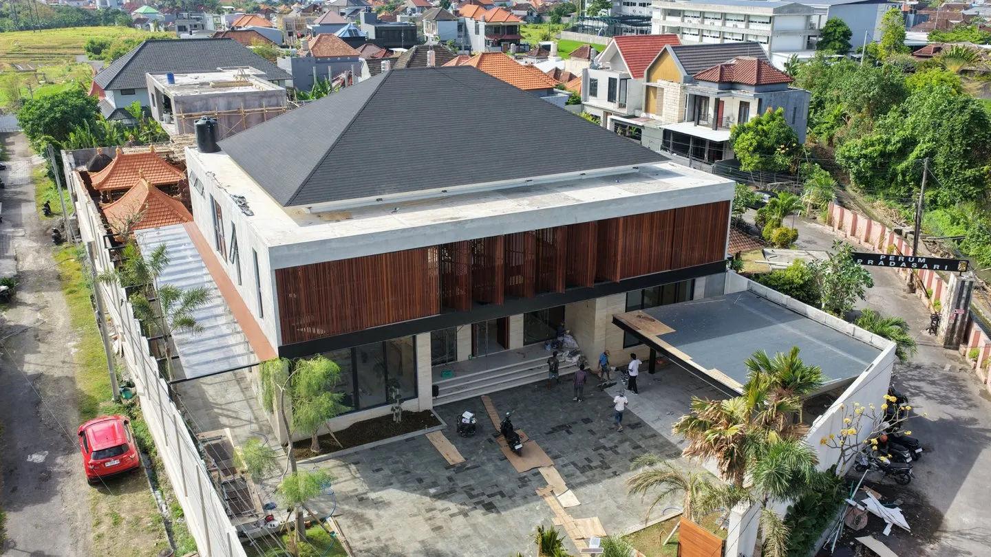 Foto udara rumah dua lantai berpanel kayu di lingkungan perumahan.