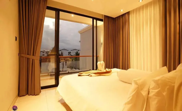 Kamar tidur dengan tirai cokelat dan pintu geser kaca.