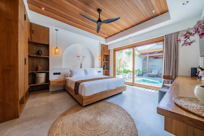 Kamar tidur berlangit-langit kayu dengan karpet anyaman bundar.