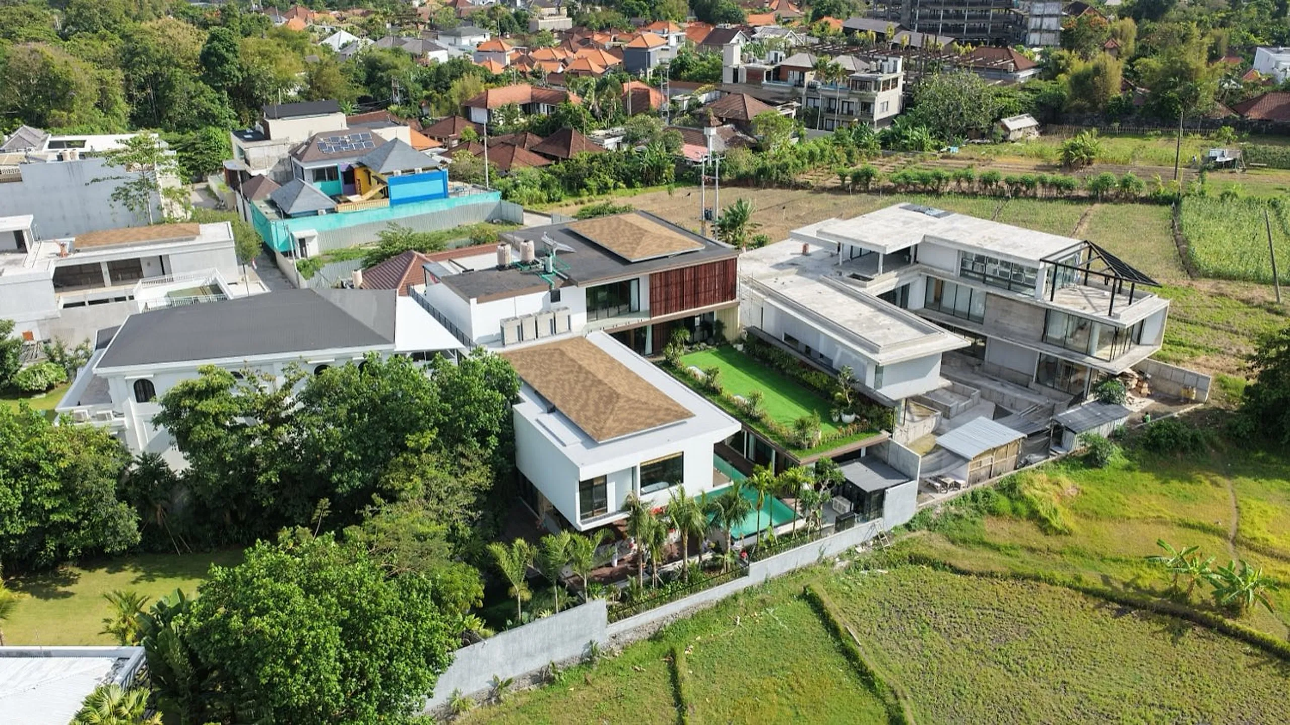 Foto udara kompleks Villa Natsu dikelilingi pepohonan dan sawah.