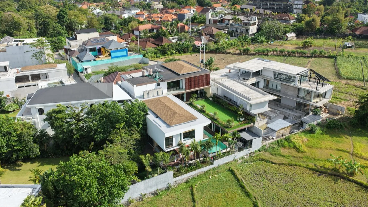 Foto udara kompleks Villa Natsu dikelilingi pepohonan dan sawah.